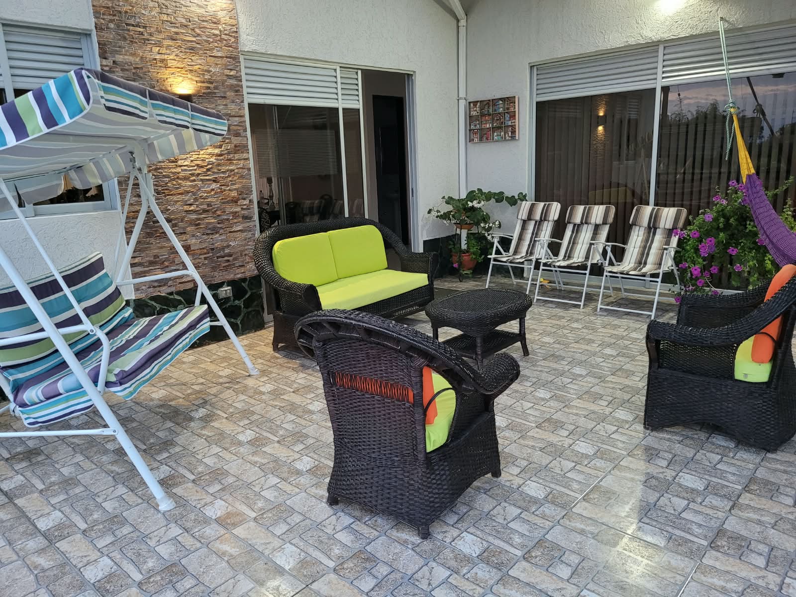 Terraza con muebles de mimbre y columpio
