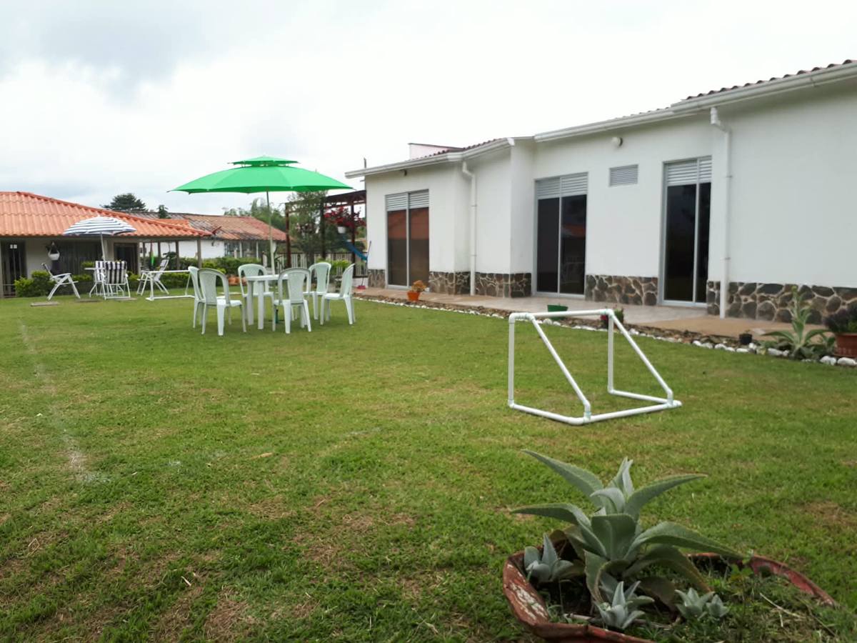 Arco de minifútbol, mesa y sombrillas en el jardín